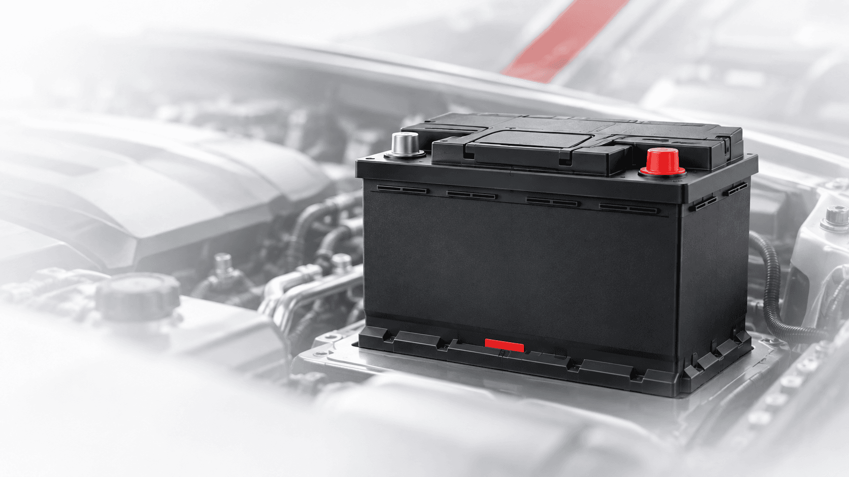 Modern black automotive battery in a light engine bay